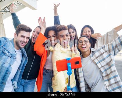 Eine Gruppe verschiedener junger Freunde, die in einer Stadt ein Selfie machen und lachen Stockfoto