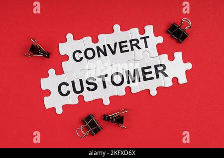 Wirtschaft und Handel. Auf einem roten Hintergrund gibt es Rätsel mit der Aufschrift - Convert Customer Stockfoto