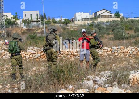 Salfit, Palästina. 20.. November 2022. Israelische Soldaten bewachen jüdische Siedler, wenn sie das Land palästinensischer Bauern im Dorf Burqin, westlich von Salfit, im besetzten Westjordanland erobern. Die Palästinenser demonstrierten gegen die Beschlagnahme ihres Landes durch diese Siedler zugunsten der jüdischen Siedlung Brochin. Kredit: SOPA Images Limited/Alamy Live Nachrichten Stockfoto