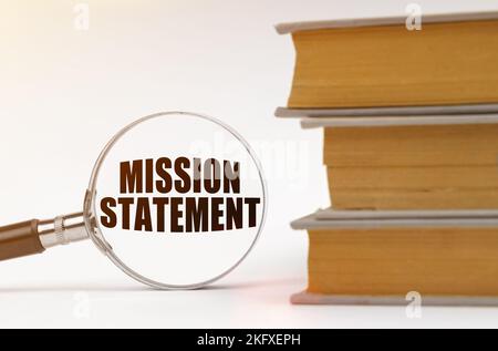 Geschäftskonzept. Auf weißem Hintergrund, Bücher und eine Lupe, in der es steht - Mission Statement Stockfoto