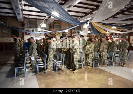 CAMP LEMONNIER, DSCHIBUTI (OKT 13, 2022) Matrosen und andere Militärangehörige, die im Camp Lemonnier stationiert sind, verneigen sich bei der Anrufung zu einer Feierstunde, die am 13. Oktober 2022 im 11 Grad Nord Veranstaltungsgebäude zu Ehren des 247.. Geburtstages der Marine stattfand. Das Thema der diesjährigen Geburtstagsfeier lautete „On Watch - 24/7 for 247 years“. Stockfoto