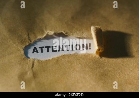 Wirtschafts- und Geschäftskonzept. Zerrissenes Papier in der Mitte des Blattes, innen auf weißem Hintergrund die Inschrift - ACHTUNG Stockfoto