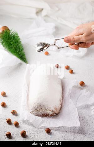 Gestohlener köstlicher Weihnachtskuchen mit Früchten und Nüssen auf hellem Hintergrund Stockfoto