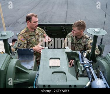 Ein dem Bataillon 1. zugewiesener Soldat, 3. Aviation Regiment (Angriffsbataillon), spricht mit einem dem Bataillon 5. zugeordneten Soldaten, 4. Air Defense Artillery, während er auf dem Flugfeld der Armee Katterbach, Deutschland, am 13. Oktober 2022, auf der Rückseite eines Manövers zur Kurzstreckensektion steht. Die Flieger lieferten einen Fähigkeitsbericht über mehrere Drehflügelanlagen, und die Luftverteidiger gaben einen Fähigkeitsbericht über das Manöver-Kurzstreckensystem zur Luftabwehr. Die 12. Combat Aviation Brigade ist unter anderem dem V Corps, dem amerikanischen Vorwärts-Einsatzkorps in Europa, zugeordnet. Sie arbeiten alongsi Stockfoto