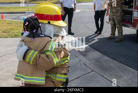 Ein Kind aus dem Child Development Center erhält eine Umarmung von Sparky, dem Feuerhund, dem offiziellen Maskottchen der National Fire Protection Association, während der Fire Prevention Week Tour im CDC auf dem Keesler Air Force Base, Mississippi, 13. Oktober 2022. Die ganze Woche hindurch führte die Keesler Feuerwehr willkürliche Feuerübungen durch, besichtigte verschiedene Einrichtungen mit Sparky, dem Feuerwehrhund, gab Brandschutzinformationen und Feuermützen für Kinder heraus. Stockfoto