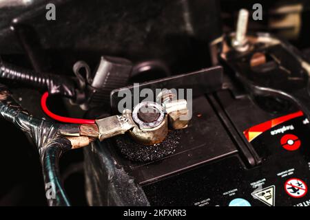 Die positive Klemme der Autobatterie mit den Anschlusskabeln der Fahrzeuganlage Stockfoto