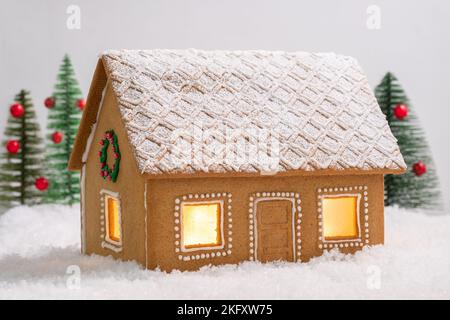 Lebkuchen-Haus im Schnee mit funkelnden silbernen hellen Hintergrund Stockfoto