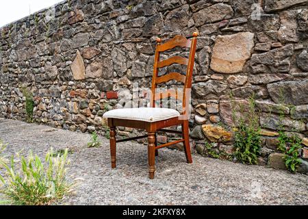 Esszimmerstuhl aus Holz links in der Straße Stockfoto