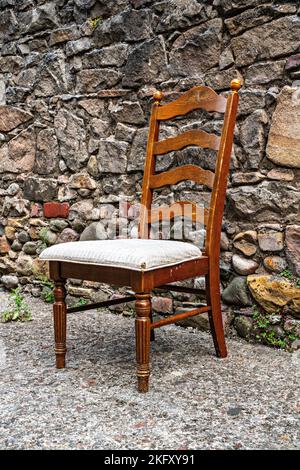 Esszimmerstuhl aus Holz links in der Straße Stockfoto