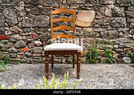 Esszimmerstuhl aus Holz links in der Straße Stockfoto