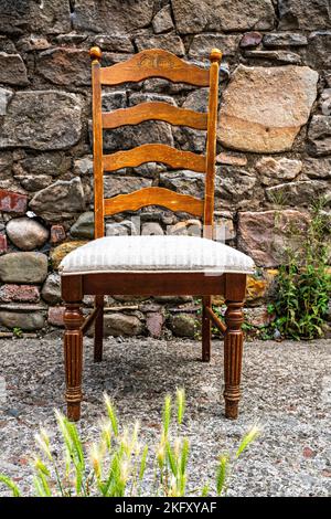 Esszimmerstuhl aus Holz links in der Straße Stockfoto