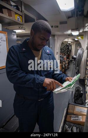 221014-N-KU796-1007 PAZIFISCHER OZEAN (OKT 14, 2022) U.S. Navy Logistics Specialist 2. Class Dearius Taylor, aus Snellville, Georgia, verarbeitet Belege an Bord des Flugzeugträgers USS Nimitz (CVN 68). Die Nimitz Strike Group bereitet sich derzeit auf eine bevorstehende Bereitstellung vor. Stockfoto