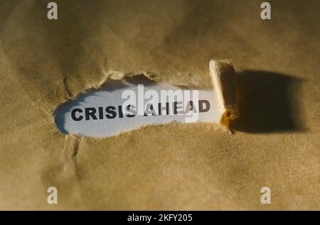 Wirtschafts- und Geschäftskonzept. Zerrissenes Papier in der Mitte des Blattes, innen auf weißem Hintergrund die Inschrift - CRISIS AHEAD Stockfoto