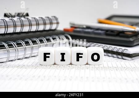 Geschäfts- und Finanzkonzept. Auf dem Tisch, zwischen Büroobjekten, Würfel mit der Aufschrift - FIFO Stockfoto