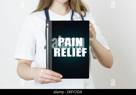 Medizin und Gesundheitskonzept. Der Arzt hält eine Tablette mit der Aufschrift - SCHMERZLINDERUNG Stockfoto