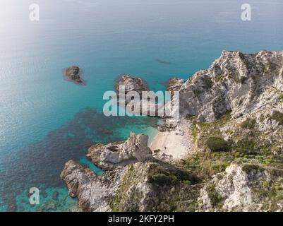 Eine Luftaufnahme der Meereswellen brechen felsigen Strand in Capo Vaticano Stockfoto