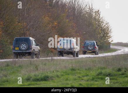 Drei modifizierte Geländewagen im Geländewagen, die auf einer Schlammspur fahren, Wilts UK Stockfoto