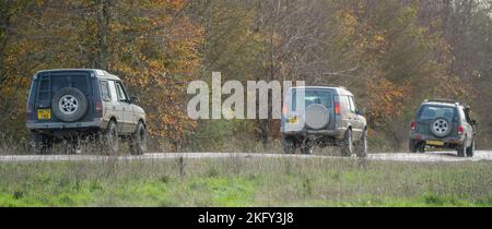 Drei modifizierte Geländewagen im Geländewagen, die auf einer Schlammspur fahren, Wilts UK Stockfoto