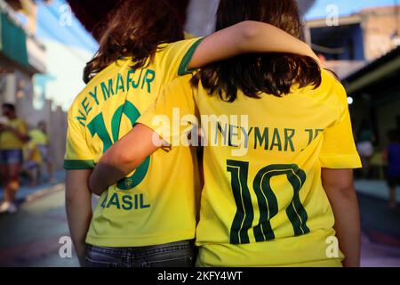 Manaus, Brasilien. 19.. November 2022. Fußball, Weltmeisterschaft 2022 in Katar. In brasilianischen Fußballtrikots mit der Nummer 10, Neymar JR, laufen zwei Mädchen Arm in Arm entlang einer Stadtstraße, die für die Weltmeisterschaft in Katar dekoriert ist. Kredit: Lucas Silva/dpa/Alamy Live Nachrichten Stockfoto