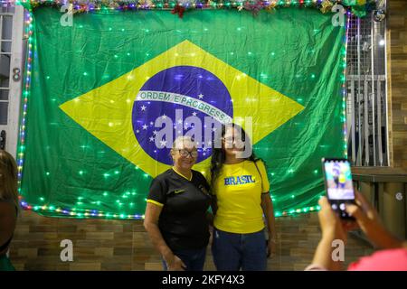 Manaus, Brasilien. 19.. November 2022. Fußball, Weltmeisterschaft 2022 in Katar. Zwei Frauen lassen sich vor der brasilianischen Nationalflagge fotografieren. Kredit: Lucas Silva/dpa/Alamy Live Nachrichten Stockfoto