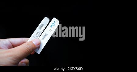 Eigene Hand mit negativem Covid-19-Testergebnis mit SARS CoV-2 Rapid Antigen Test Kit (ATK) und schwarzem Hintergrund mit Kopierraum, Coronavirus infectiou Stockfoto