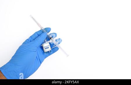 Impfstoffflasche mit Monkeypox- und Pockenvirus (MPXV) und Spritze in einer Hand des medizinischen Personals mit horizontalem Kopierbereich auf weißem Hintergrund Stockfoto