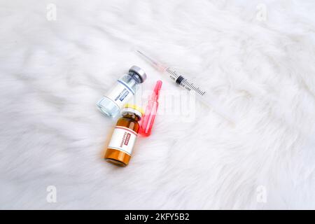 Impfstoffflasche mit Monkeypox- und Pockenvirus (MPXV), Medikamentenampulle und Spritze auf weißem Teppichgrund Stockfoto