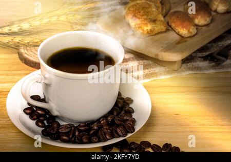 Kaffeepause am Morgen, Kaffeetasse und geröstete Kaffeebohnen auf Holztisch mit Sonnenlicht Stockfoto