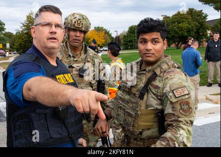 Von links gibt ein Mitglied der Delaware State Police Meister Sgt zu. Ritchie Brown, Flugchef der Sicherheitskräfte 436. und Senior Airman Louis Giardino, Mitglied der 436. SFS-Einsatztruppe, während einer aktiven Schützenübung, die auf der Maj. George S. Welch Elementary und der Mittelschule der Luftwaffenbasis Dover auf der Luftwaffenbasis Dover, Delaware, am 14. Oktober 2022 stattfand. An der Übung beteiligten sich zahlreiche Basisbehörden und Community-Ersthelfer, die gemeinsam daran arbeiteten, den simulierten aktiven Shooter zu neutralisieren. Stockfoto