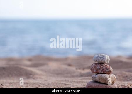 An der Küste liegen runde Steine übereinander in einer Säule Stockfoto