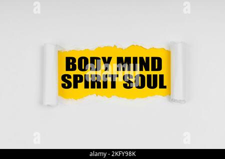 Geschäfts- und Finanzkonzept. Ein Fenster ist im Papier gemacht, wo auf einem gelben Hintergrund die Inschrift - Body Mind Spirit Soul Stockfoto