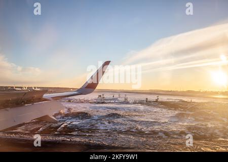 Der Flügel und das Land des Flugzeugs werden durch den Strahler gesehen. Stockfoto
