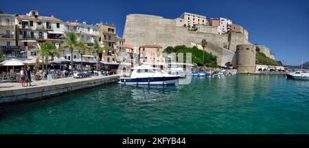 CALVI, KORSIKA, FRANKREICH; 21. August 2020: Touristen, die entlang der Küste von Calvi im Norden Korsikas spazieren. Die Stadt ist berühmt für die massive Festung der Zitadelle Stockfoto