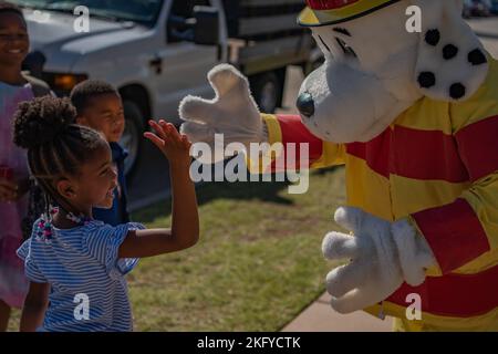 Denver Jackson, Dyess Elementary Kindergärtner, und Sparky, 7. Civil Engineer Squadron Fire Department Maskottchen, High Five während der Smokehouse Erfahrung auf Dyess Air Force Base, Texas, 14. Oktober 2022. Sparky, das offizielle Maskottchen der National Fire Protection Association, lehrt Kinder, Brandschutz zu üben. Stockfoto