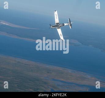 Ein T-6 Texan II dreht sich am Himmel von Florida als Teil von Ambush Florida am 14. Oktober 2022. Ambush Florida ist eine Mission, bei der Piloten des Flying Training Squadron von 85. in eine andere Region der USA fliegen und andere Stützpunkte „überfallen“, um Piloten bei Langstreckenflügen zu helfen, Erfahrungen zu sammeln. Stockfoto