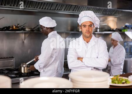 Portrait des Küchenchefs mit gekreuzten Armen in der Restaurantküche Stockfoto