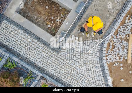 Professioneller Auftragnehmer Gebäude Garten Ziegelsteingang von Granitfertiger. Hinterhof-Design in Arbeit. Industriedesign. Luftaufnahme. Stockfoto