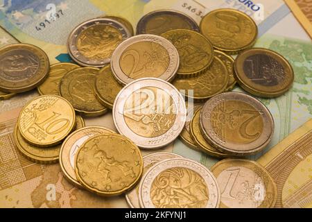 Verschiedene Euro-Münzen auf Euro-Banknoten. Stockfoto