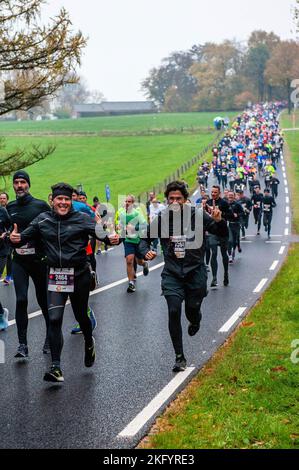 Zwei Teilnehmer werden dabei gesehen, wie sie die Kamera anfeuern. Rund 17.500 Teilnehmer liefen den 'NN Zevenheuvelenloop', der seit Jahren Tausende von Läufern aus den Niederlanden und dem Ausland nach Nijmegen lockt. Der Platz gilt als einer der schönsten des Landes. Bei den Männern gewann die ugandische Athletin Rogers Kibet mit einer Zeit von 42,08 Minuten, bei den Frauen die kenianische Athletin Beatrice Chepkoech mit einer Zeit von 47,18 Minuten. Sie liefen über die sehr bekannten sieben Hügel, die sich in Berg en Dal befinden, bevor sie in Nijmegen ankamen. Die Bedeutung von Zevenheuvelenloop im Englischen wäre s Stockfoto