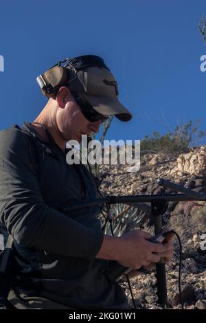 U.S. Marine Maj. Spencer Hart, ein AH-1Z Viper Pilot mit Marine Light Attack Helicopter Training Squadron (HMLAT) 303, Marine Aircraft Group 39, 3. Marine Aircraft Wing, sucht im Anza-Borrego Desert State Park, Kalifornien, am 16. Oktober 2022 nach einem großen Schafspilot. HMLAT-303 Marines und Landes-, Bundes- und Privatbehörden verwendeten Telemetrieempfänger zusammen mit UH-1Y Venom-Hubschraubern, um nach vermissten bedrohten Dickhornschafen zu suchen. Aufgrund des rauen Geländes führten die Marines des HMLAT-303 fortschrittliche Landetechniken durch. Hart stammt aus Davenport, Iowa Stockfoto