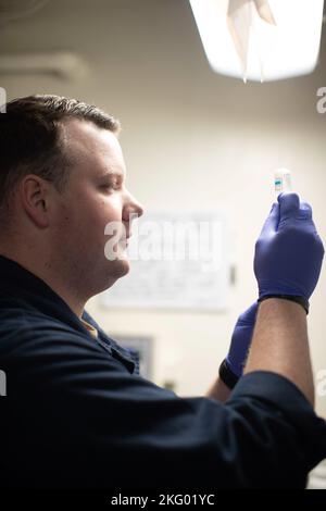 Hospital Corpsman 2. Class Austin Storie, aus Pacific, Missouri, wird der medizinischen Abteilung des First-in-Class-Flugzeugträgers USS Gerald R. Ford (CVN 78) zugewiesen und bereitet Medikamente zur Verabreichung an einen Patienten vor, 16. Oktober 2022. Die Gerald R. Ford Carrier Strike Group (GRFCSG) wird im Atlantischen Ozean eingesetzt und führt zusammen mit NATO-Alliierten und Partnern Trainings und Operationen durch, um die Integration für zukünftige Einsätze zu verbessern und das Engagement der US-Marine für eine friedliche, stabile und konfliktfreie atlantische Region zu demonstrieren. Stockfoto