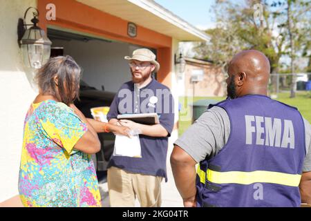 Fort Myers, FL, USA - (Okt 17, 2022) - FEMA Disaster Survivor Assistance Team spricht mit dem Überlebenden über die Registrierung für Katastrophenhilfe in einer vom Sturmporz Ian betroffenen Nachbarschaft. Stockfoto