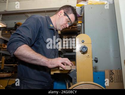 221018-N-ET093-1038 ADRIATISCHES MEER (18. Oktober 2022) Hull Maintenance Technician 1st Class Alex Smalley, aus Canano Island, Kalifornien, dem Flugzeugträger USS George H.W. Bush (CVN 77) der Nimitz-Klasse zugeteilt, sandt ein Plakat ab, 18. Oktober 2022. Die George H.W. Bush Carrier Strike Group ist auf einem geplanten Einsatz im US-Marinestreitgebiet in Europa stationiert und wird von der U.S. Sixth Fleet eingesetzt, um die Interessen der USA, Verbündeter und Partner zu verteidigen. Flugzeugträger, CVN 77, GHWB, US Navy, USS George H. W. Bush (CVN 77), Stockfoto