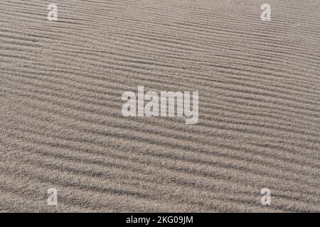 Hellbrauner Sand Textur Hintergrund, windiger Tag am Strand, Muster, abstrakt Stockfoto