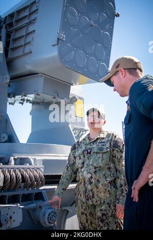 Von links: Marine Surface Warfare Center, Port Hueneme Division (NSWC PHD) Fire Controlman 1. Klasse Krystal Marshall diskutiert Reparaturoptionen mit USS Harpers Ferry (LSD 49) Elektroniktechniker Erik Nondorf bei der Behebung eines defekten Salvo-Alarms mit Rolling Airframe Missile (RAM) an Bord der USS Harpers Ferry während einer kürzlich durchgeführten Veranstaltung des Combat Systems Assessment Team bei NSWC PHD. Stockfoto