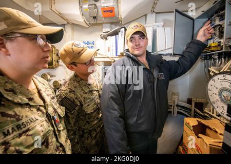 Von links: Marine Surface Warfare Center, Port Hueneme Division (NSWC PHD) Fire Controlman 1. Class Krystal Marshall und Fire Controlman 1. Class Ricardo Castro Canchola arbeiten mit USS Harpers Ferry Fire Controlman 2. Class Trevor Houf zusammen, um die Relaisschaltung für den Salvo-Alarm der Rolling Airframe Missile an Bord der USS Harpers Ferry zu überprüfen (LSD 49) Während einer kürzlich stattgefundenen Veranstaltung des Combat Systems Assessment Teams bei NSWC PHD. Stockfoto