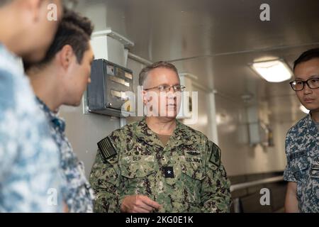 APRA HARBOUR, Guam (Okt 18, 2022) – Adm Hinten. Rick Seif, Kommandant der Submarine Group 7, beschreibt die Fähigkeiten des U-Boot-Tender USS Emory S. Land (AS 39) an Mitglieder der Republic of Singapore Navy (RSN) während der RSN-Gespräche 4. und der US-Marine Submarine Force Staff Talks, Okt. 18. Seit 2017 haben diese Unterseeboot-Gespräche Führer sowohl der US- als auch der RSN-U-Boot-Streitkräfte zusammengebracht, um über die verstärkte Interoperabilität und den Aufbau von Beziehungen zu diskutieren. Stockfoto