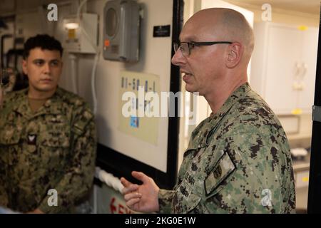 APRA HARBOUR, Guam (Okt 18, 2022) – Bef. Bryan Kupyar, Executive Officer des U-Boot-Reeders USS Emory S. Land (AS 39), beschreibt die zahnärztlichen Fähigkeiten des Schiffes an Mitglieder der Republic of Singapore Navy (RSN) während der RSN-Gespräche 4. und der US Navy Submarine Force Staff Talks, Oktober 18. Seit 2017 haben diese Unterseeboot-Gespräche Führer sowohl der US- als auch der RSN-U-Boot-Streitkräfte zusammengebracht, um über die verstärkte Interoperabilität und den Aufbau von Beziehungen zu diskutieren. Stockfoto