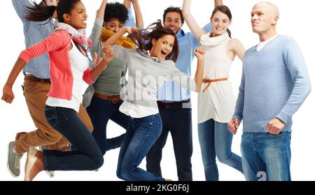 Voller Leben. Gruppe von lässig gekleideten jungen Erwachsenen, die aufgeregt vor weißem Hintergrund springen. Stockfoto