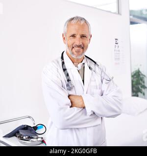 Erfahren, freundlich und professionell. Porträt eines hübschen reifen Arztes, der in einem Krankenhauszimmer steht. Stockfoto